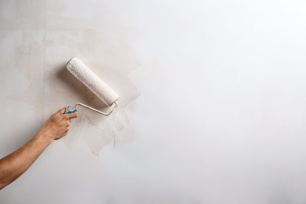 Close up of man painting wall with roller