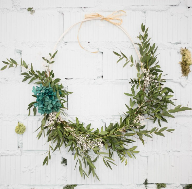 Decorative wreath attached on white brick wall