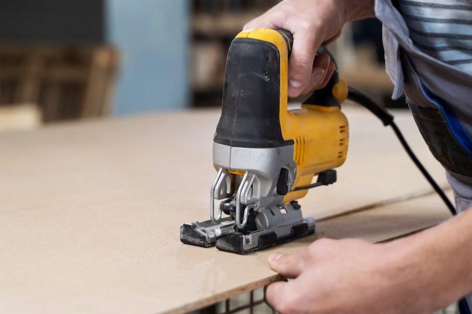 man sands the wooden board while holding it