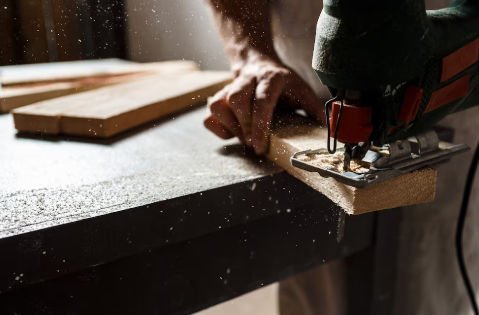 man’s hands sanding the wooden board