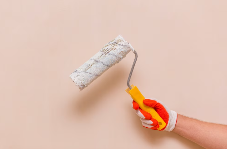 hands with gloves holding platen in front of pink wall