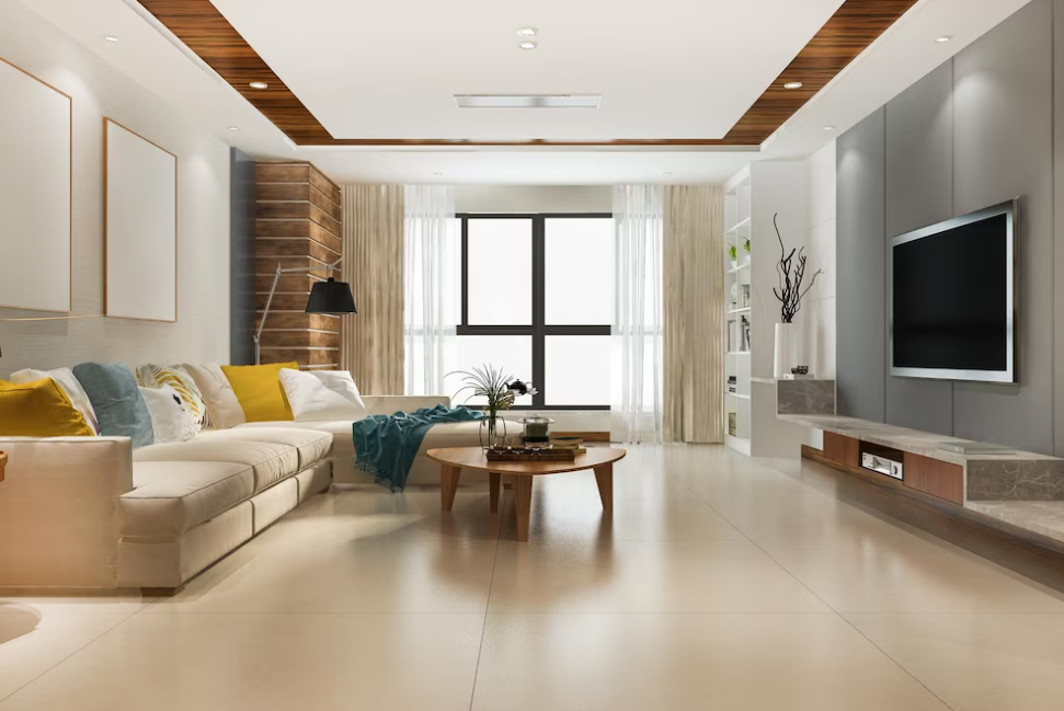 a living room with sofa and pillows on it, coffee table with vase, lamp, window and tv on the wall